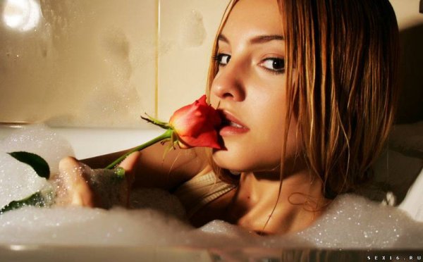 Красивая молодая девушка позирует в ванне