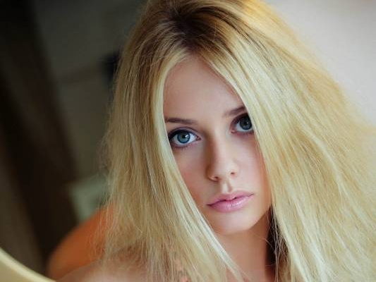 Красивая блондинка эротично позирует на кровати